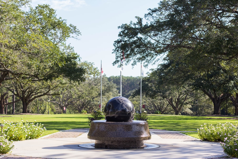 gray round statue on green grass field during daytime