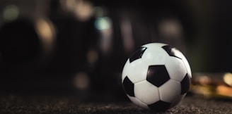 white and black soccer ball on black sand