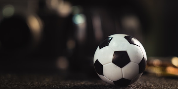 white and black soccer ball on black sand