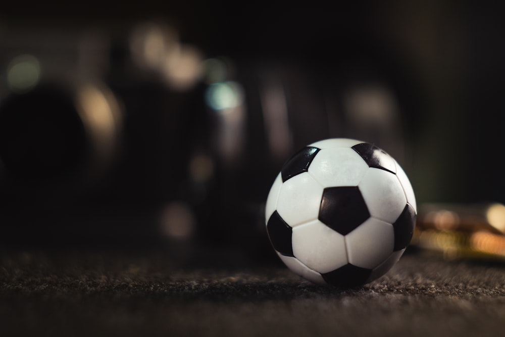 Ballon de football blanc et noir sur sable noir