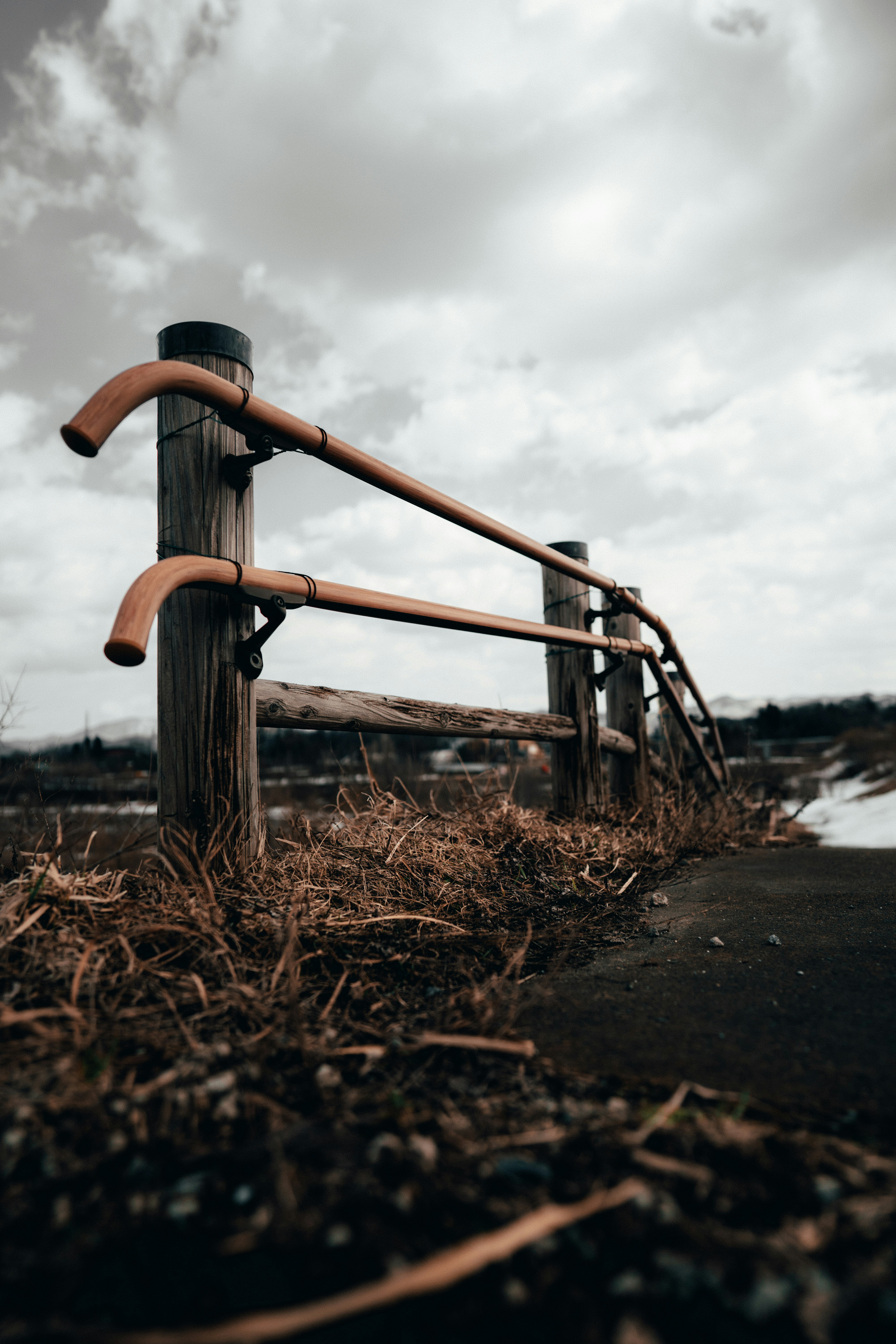 Brown metal railings on brown grass field near body of water during ...