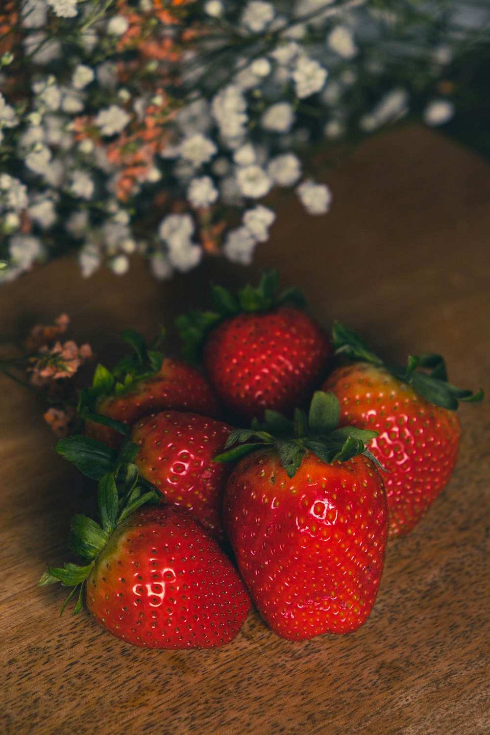 red strawberries on brown wooden table