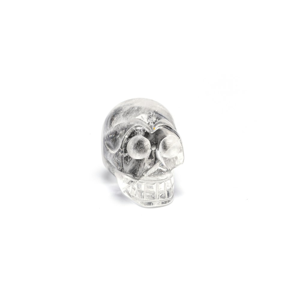 clear glass skull ornament on white surface
