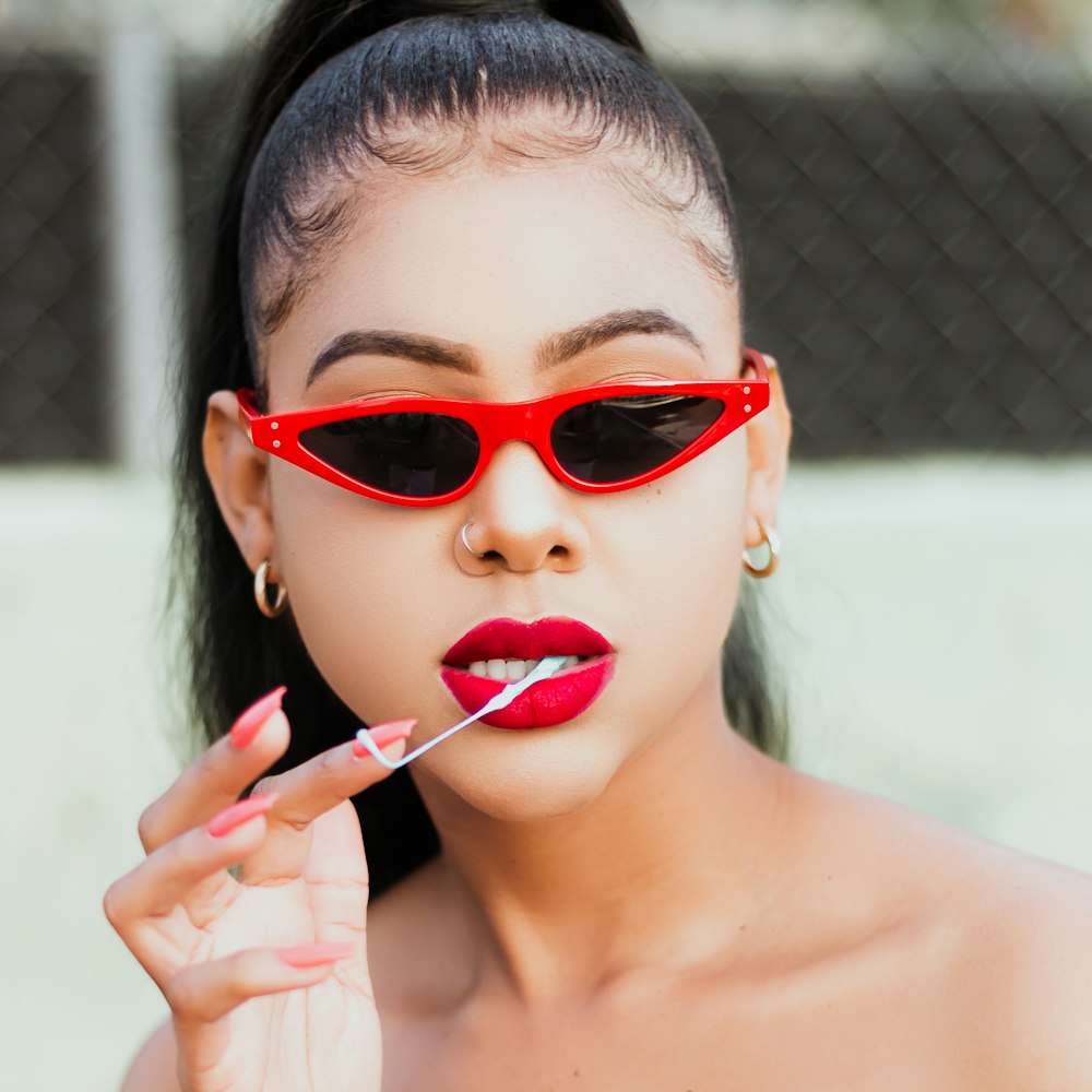 woman in red framed sunglasses