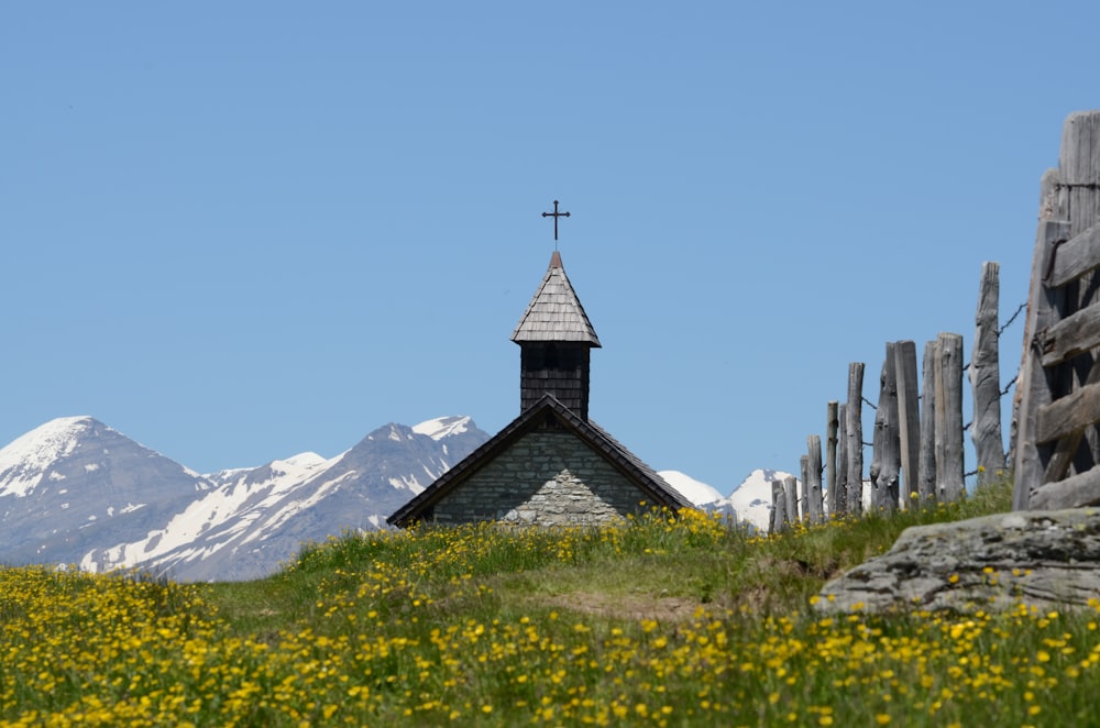 Iglesia de hormigón gris cerca de la montaña cubierta de nieve durante el día