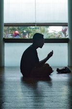 man in black shirt sitting on floor