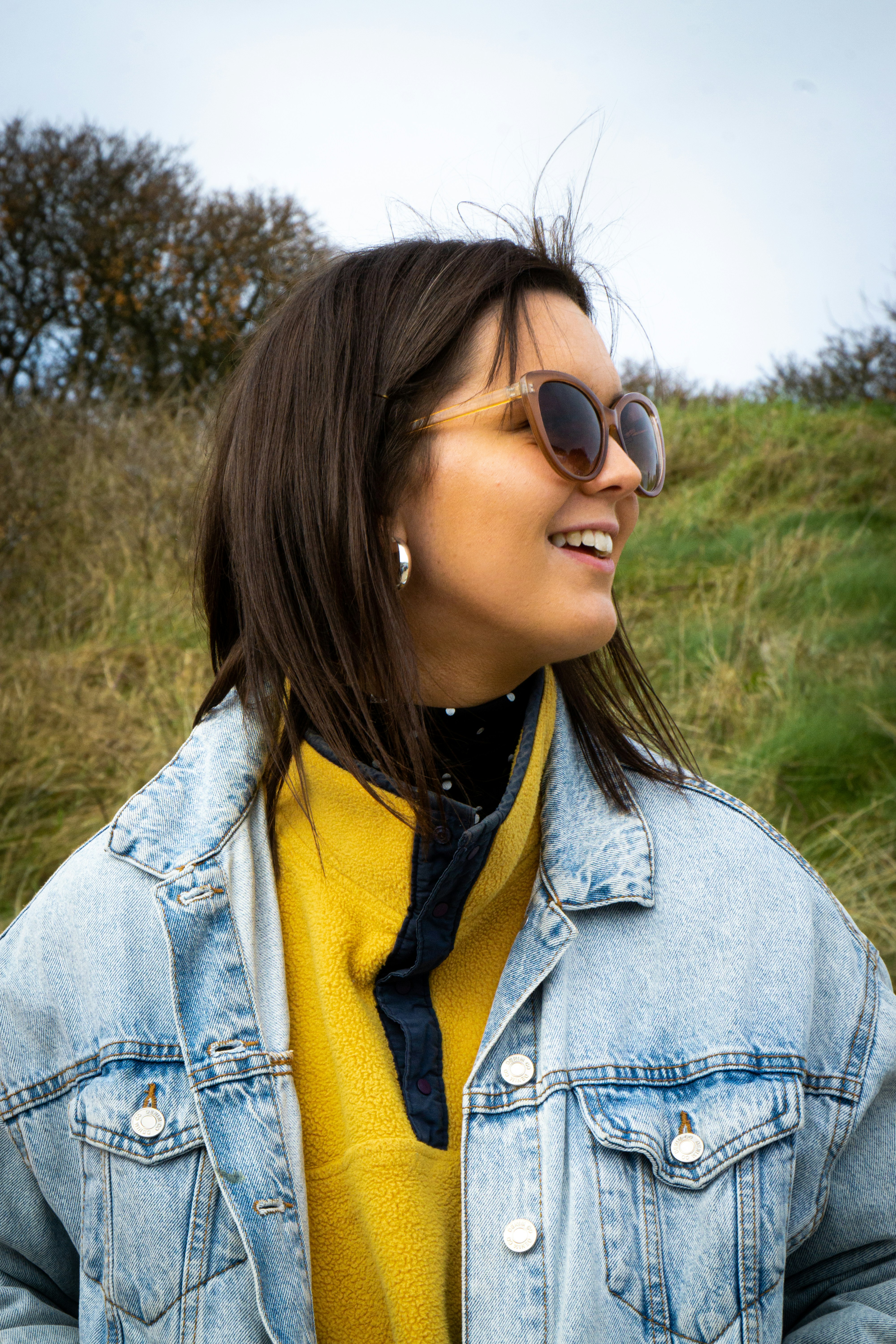 Person wearing grey fleece jacket in bright outdoor setting