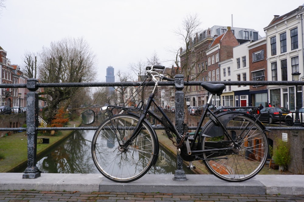 black city bike parked beside black metal fence during daytime