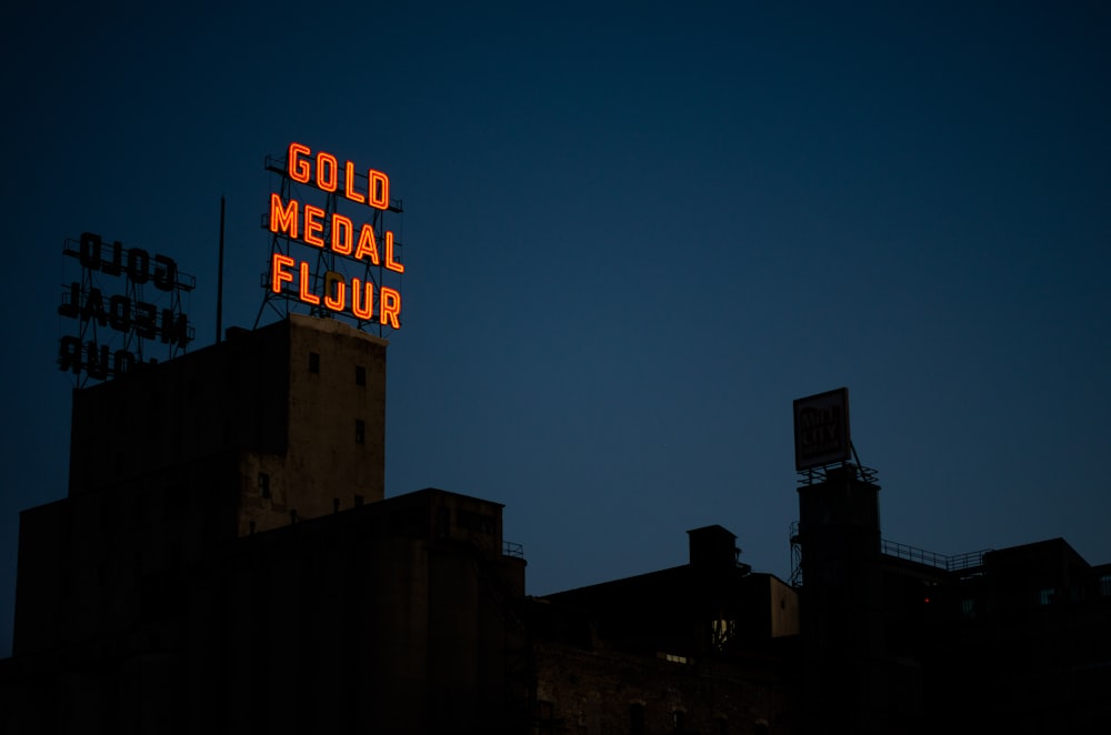 a neon sign that reads gold medal flour on top of a building