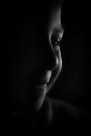 A close-up of a child's face illuminated by gentle light, showing a hopeful smile