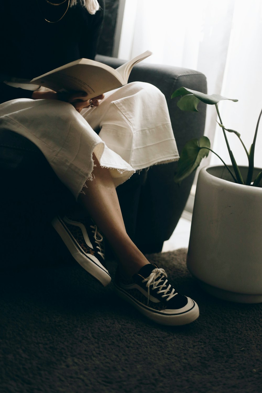 person in black and white converse all star high top sneakers