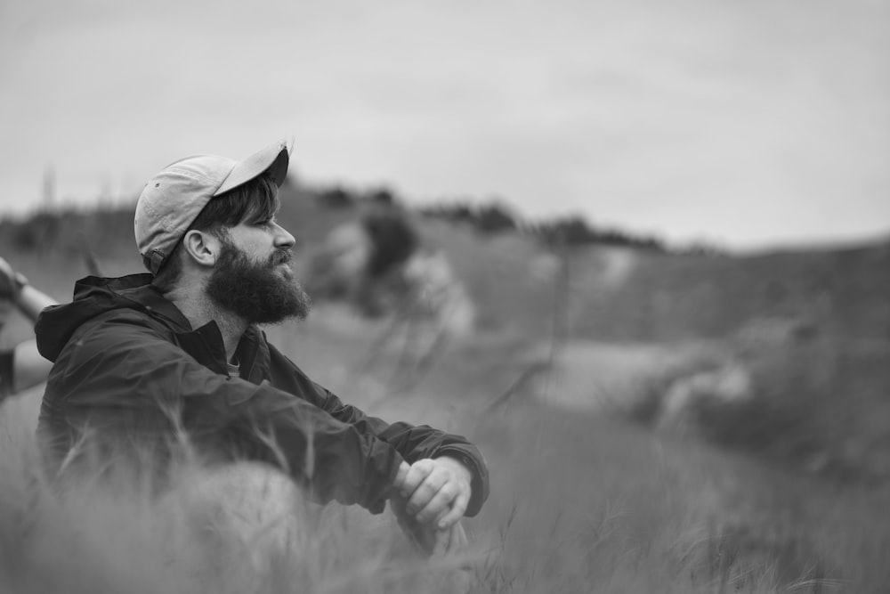 grayscale photo of man in jacket and cap