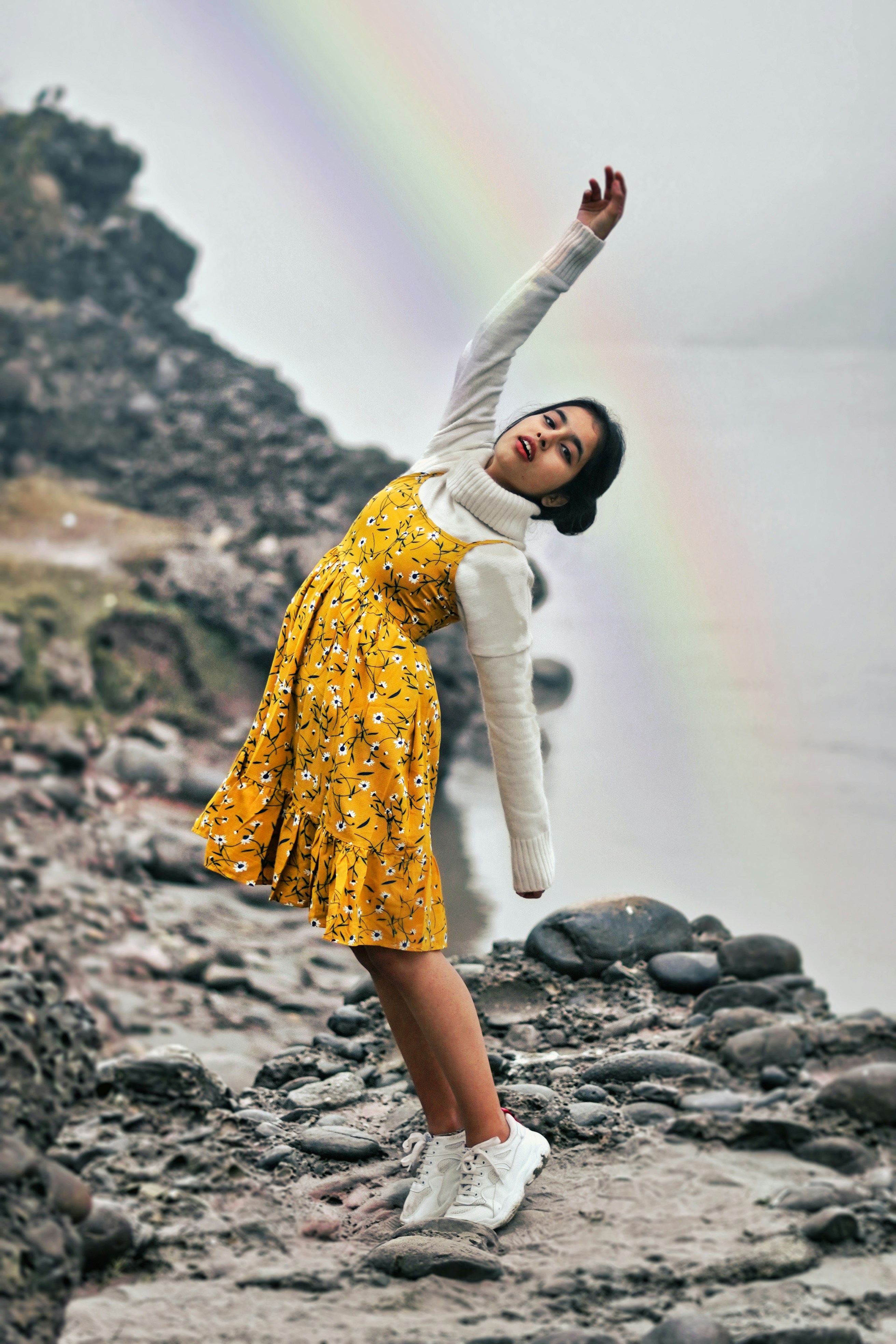 woman in yellow dress standing on rock during daytime