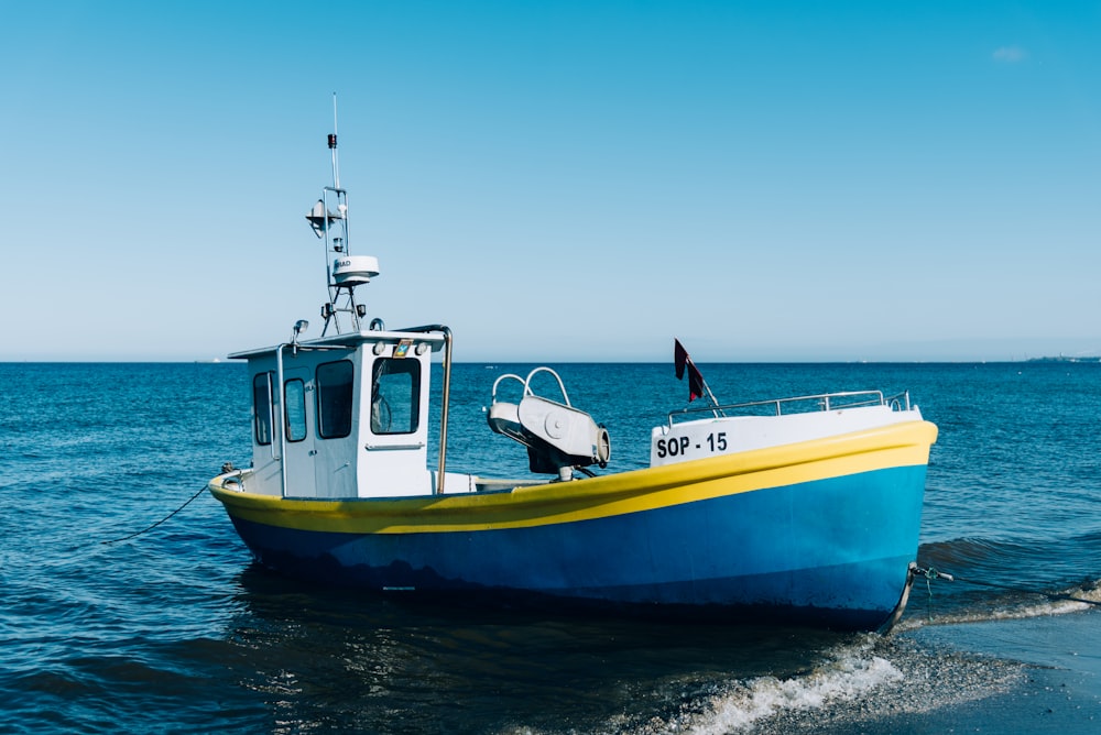 Barca gialla e bianca sul mare durante il giorno