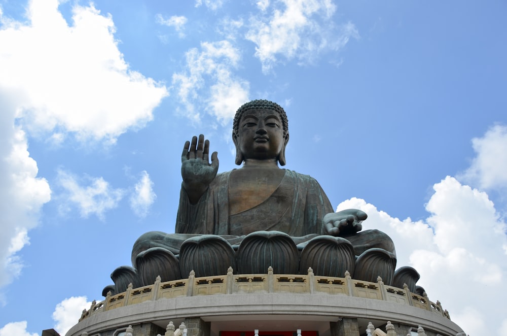 estátua de concreto cinzenta sob o céu azul durante o dia