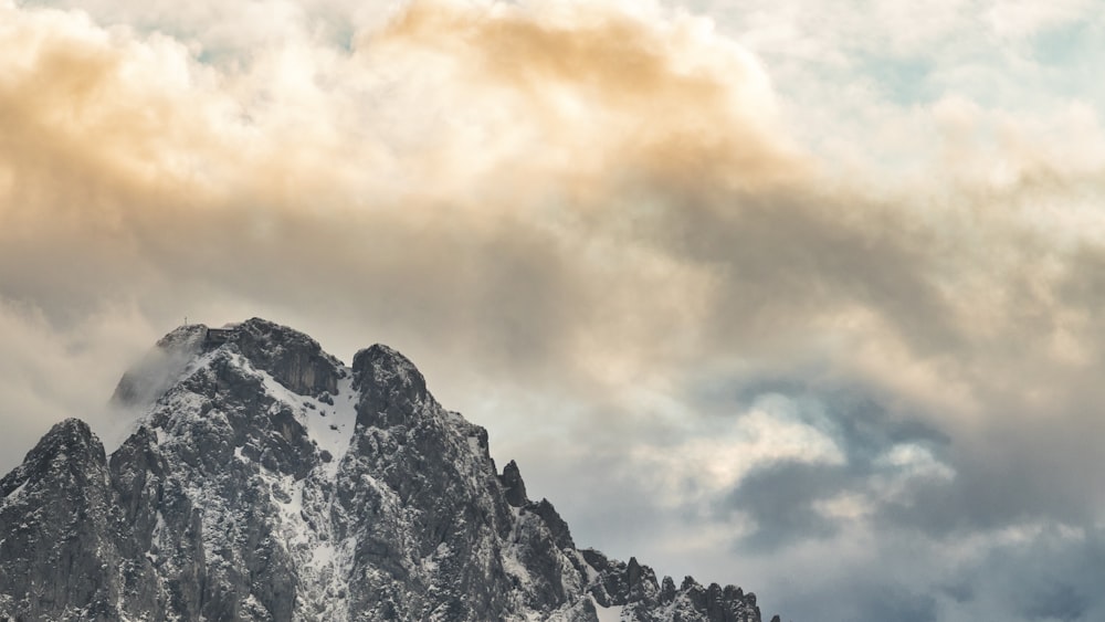 snow covered mountain under cloudy sky during daytime