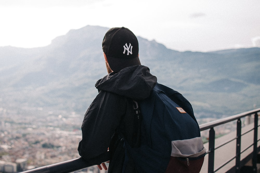 man in black hoodie wearing black and white cap