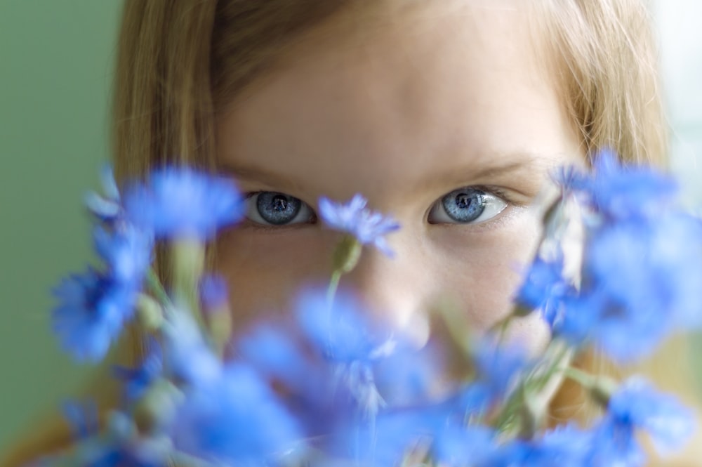 ragazza con fiori blu e bianchi sul suo viso