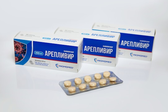 Several boxes of medication labeled Areplivir are displayed with a blister pack containing tablets in front. The packaging primarily features blue and white colors with some text and branding elements.