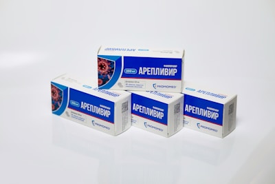Several boxes of Areplivir medication are displayed on a clean white surface. Each box features prominent blue and white colors with text in a foreign language. The design includes an image resembling a microscopic view of a virus.