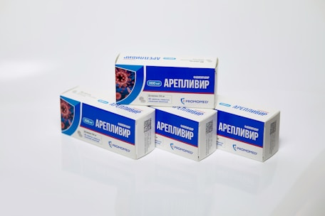 Several boxes of Areplivir medication are displayed on a clean white surface. Each box features prominent blue and white colors with text in a foreign language. The design includes an image resembling a microscopic view of a virus.