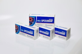 Several boxes of Areplivir medication are displayed on a clean white surface. Each box features prominent blue and white colors with text in a foreign language. The design includes an image resembling a microscopic view of a virus.