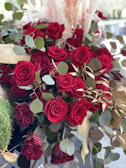 An elegant arrangement of deep red roses and eucalyptus leaves, perfect for a romantic gesture.