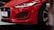 Close-up of the front of a red Jaguar F-Type car, featuring details of the headlight, grille, and sporty exterior design.
