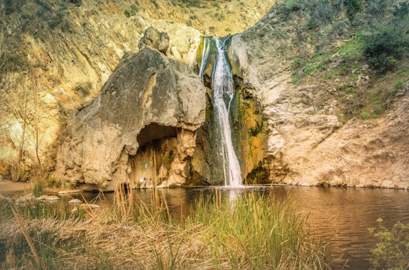 waterfalls in the middle of green grass field