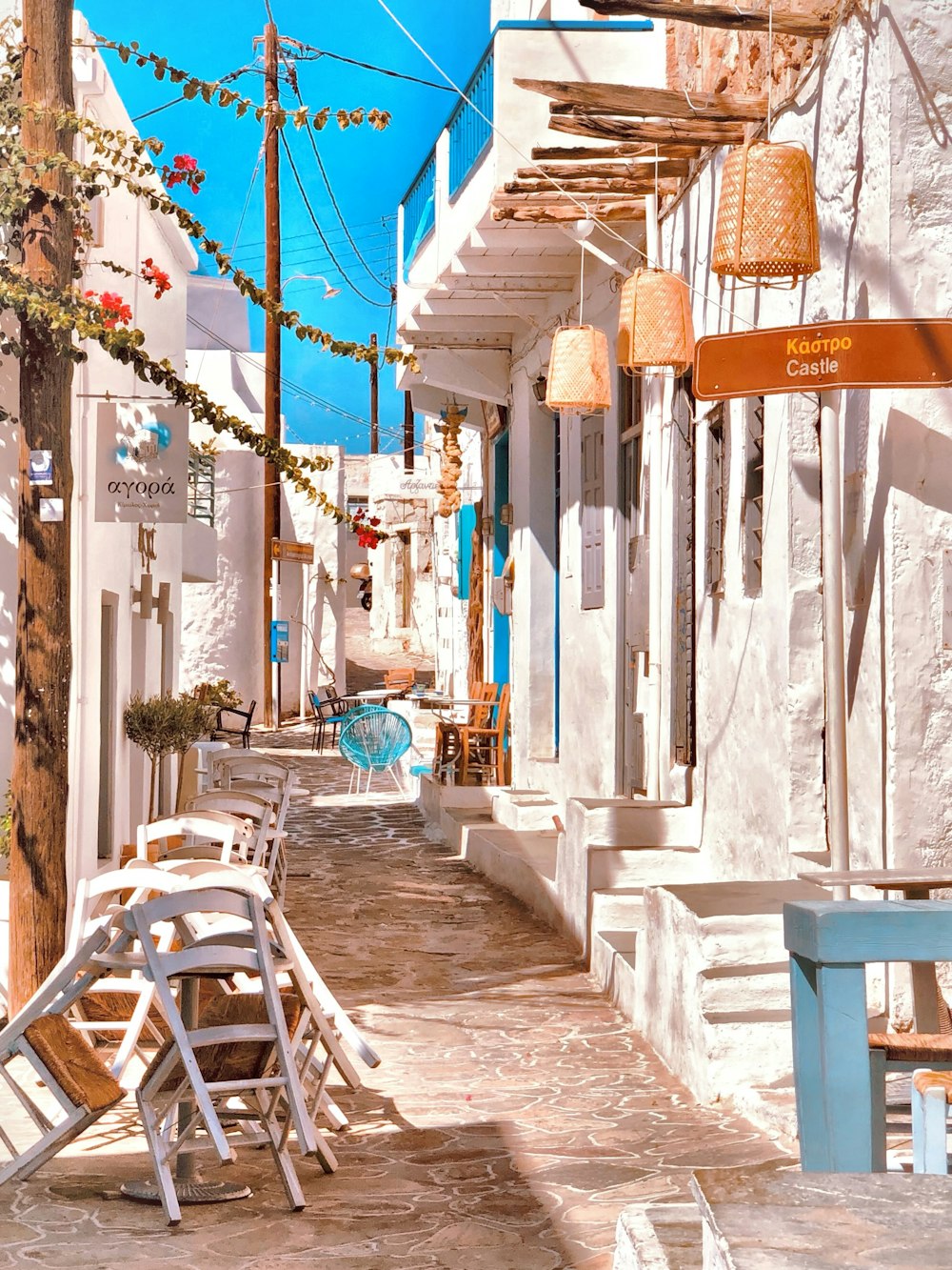 white and blue wooden chairs and tables on sidewalk during daytime