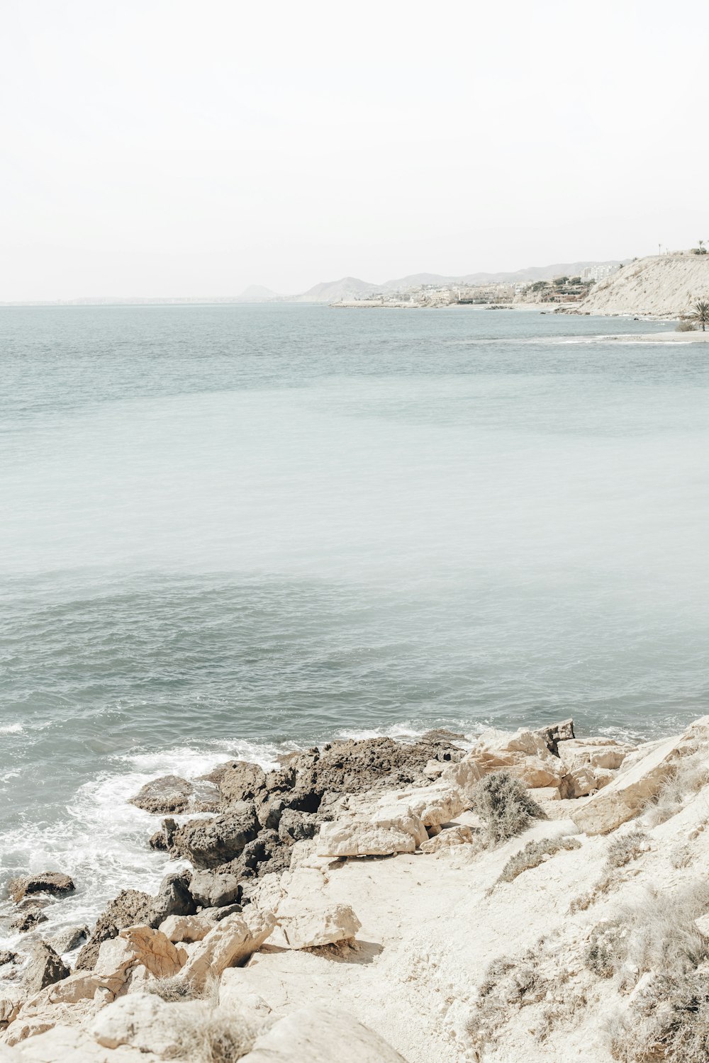 brown rocky shore with blue sea water during daytime