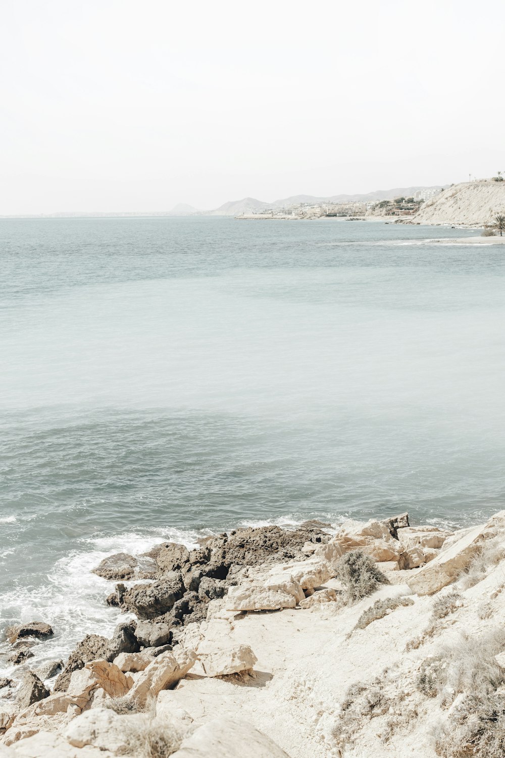 costa rocciosa marrone con acqua di mare blu durante il giorno