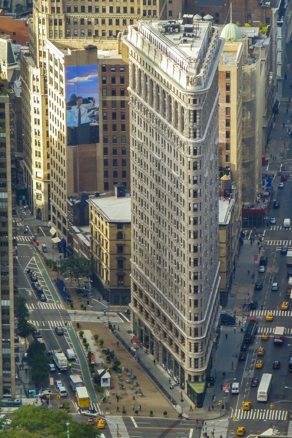 cars on road in between high rise buildings during daytime