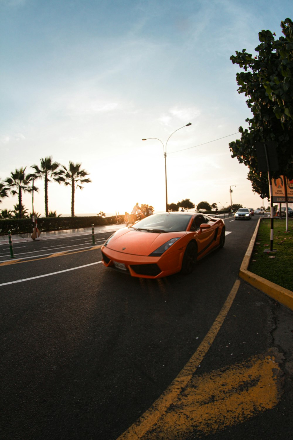 orange sports car on road during daytime