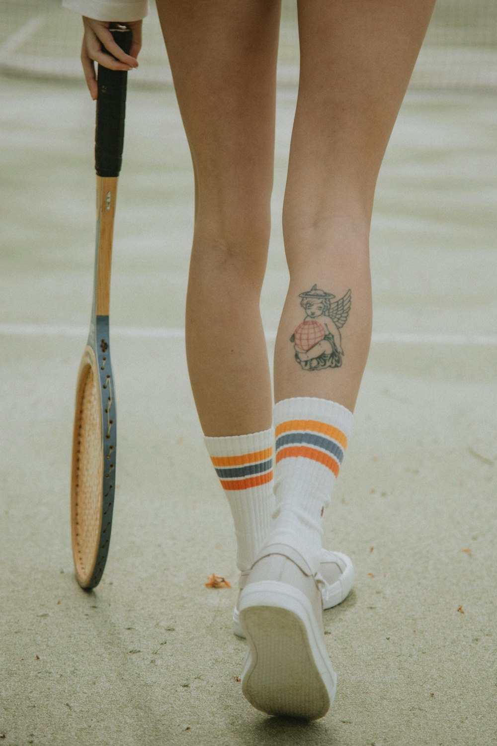 person in white socks and white socks with black and red star tattoo on right leg