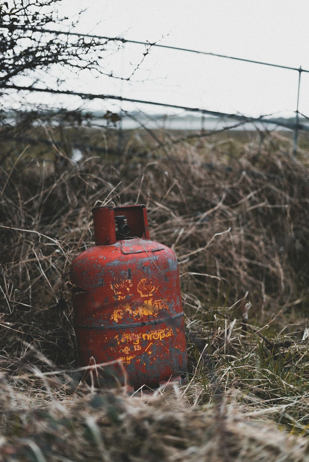 red gas tank on green grass field