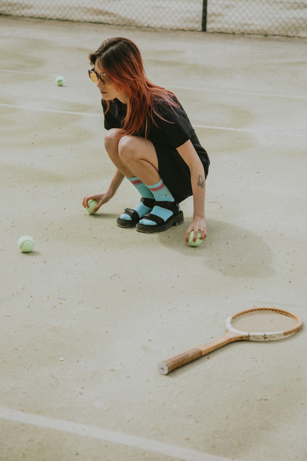 woman in black tank top and black shorts playing tennis