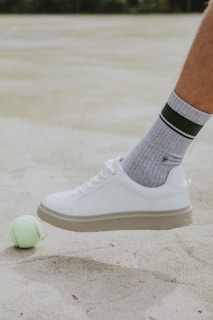 person wearing white nike sock and white nike low top sneaker