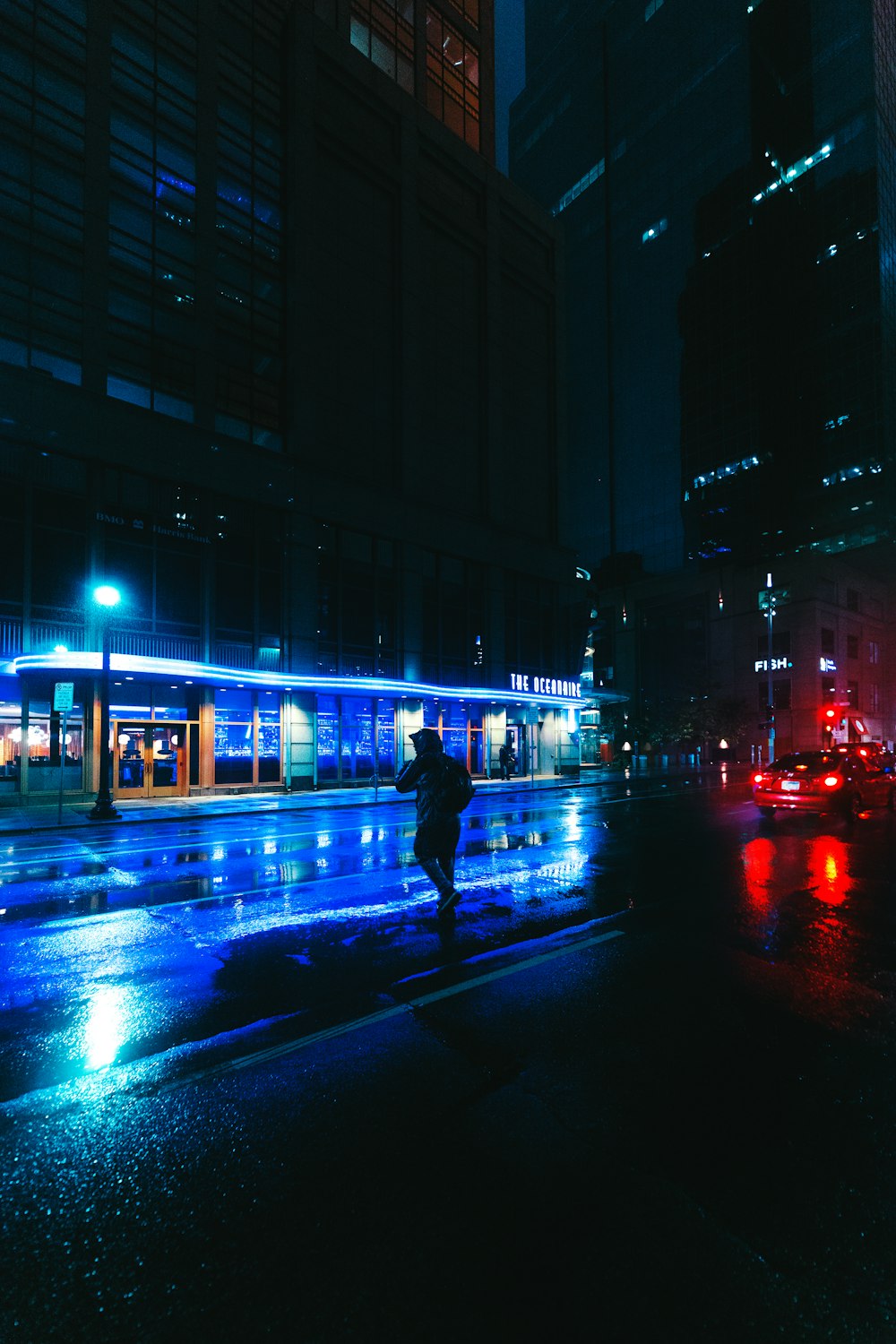 man in black jacket walking on street during night time