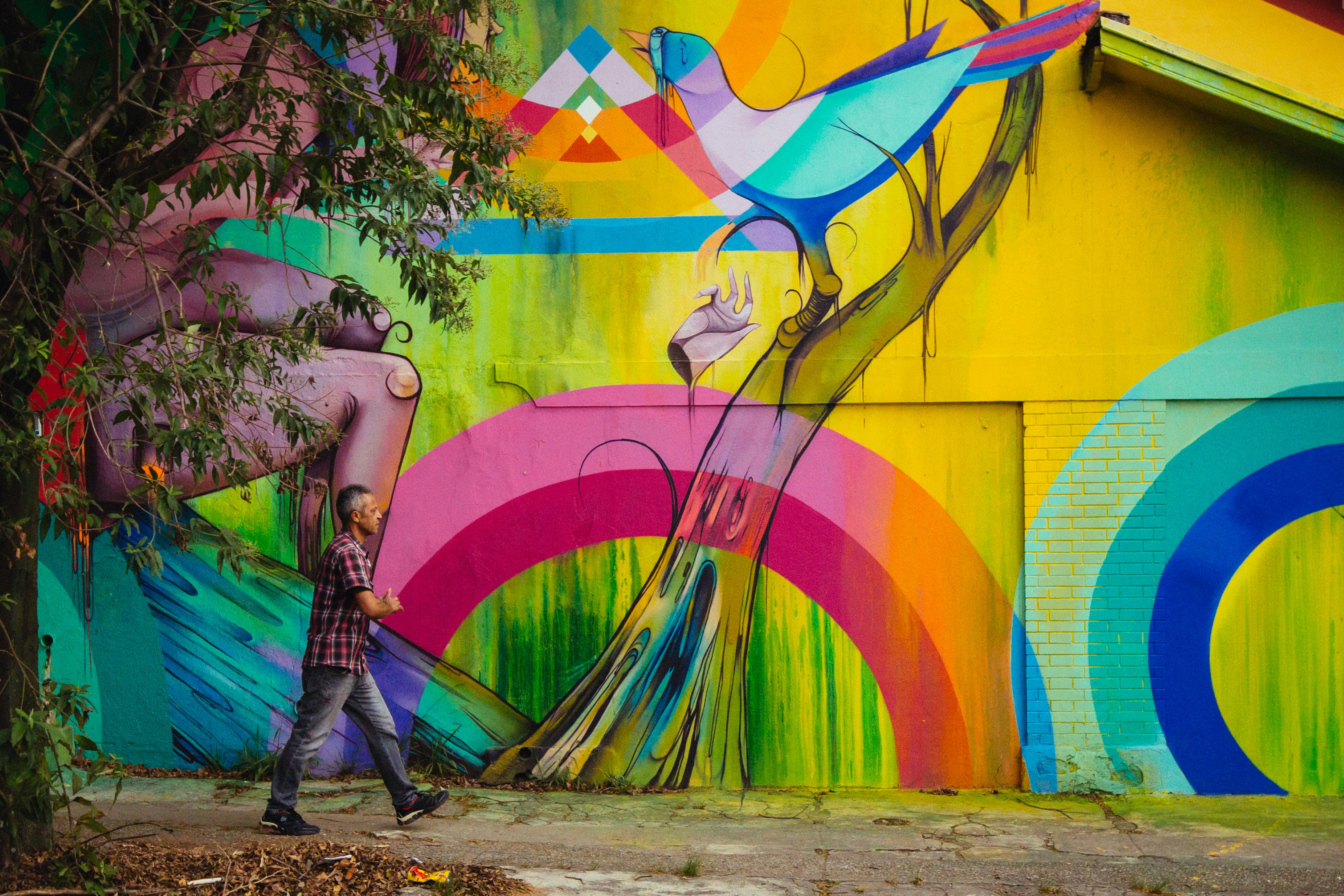 woman in black leather boots standing beside wall with graffiti, 