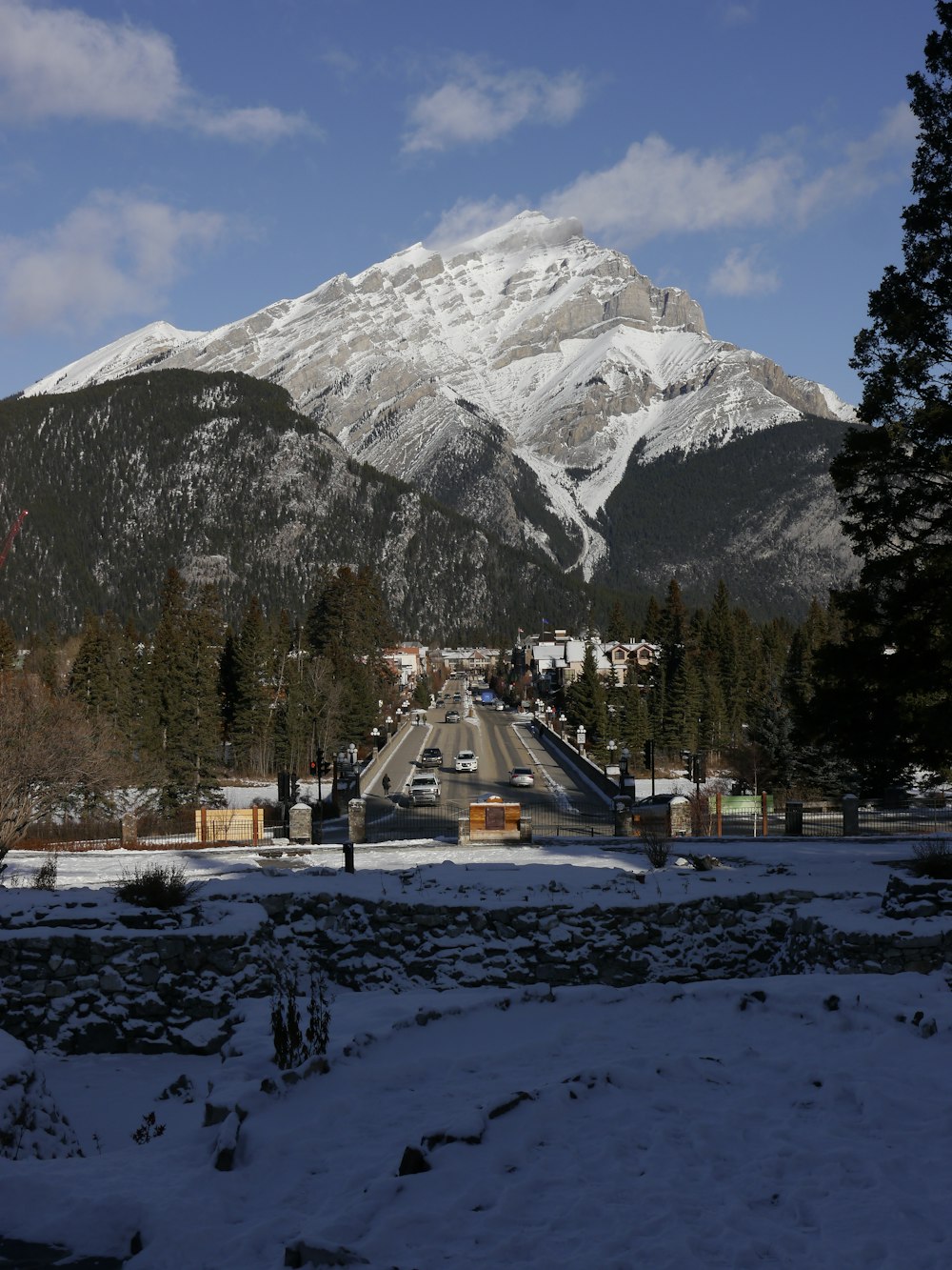 white and brown house near trees and snow covered mountain during daytime