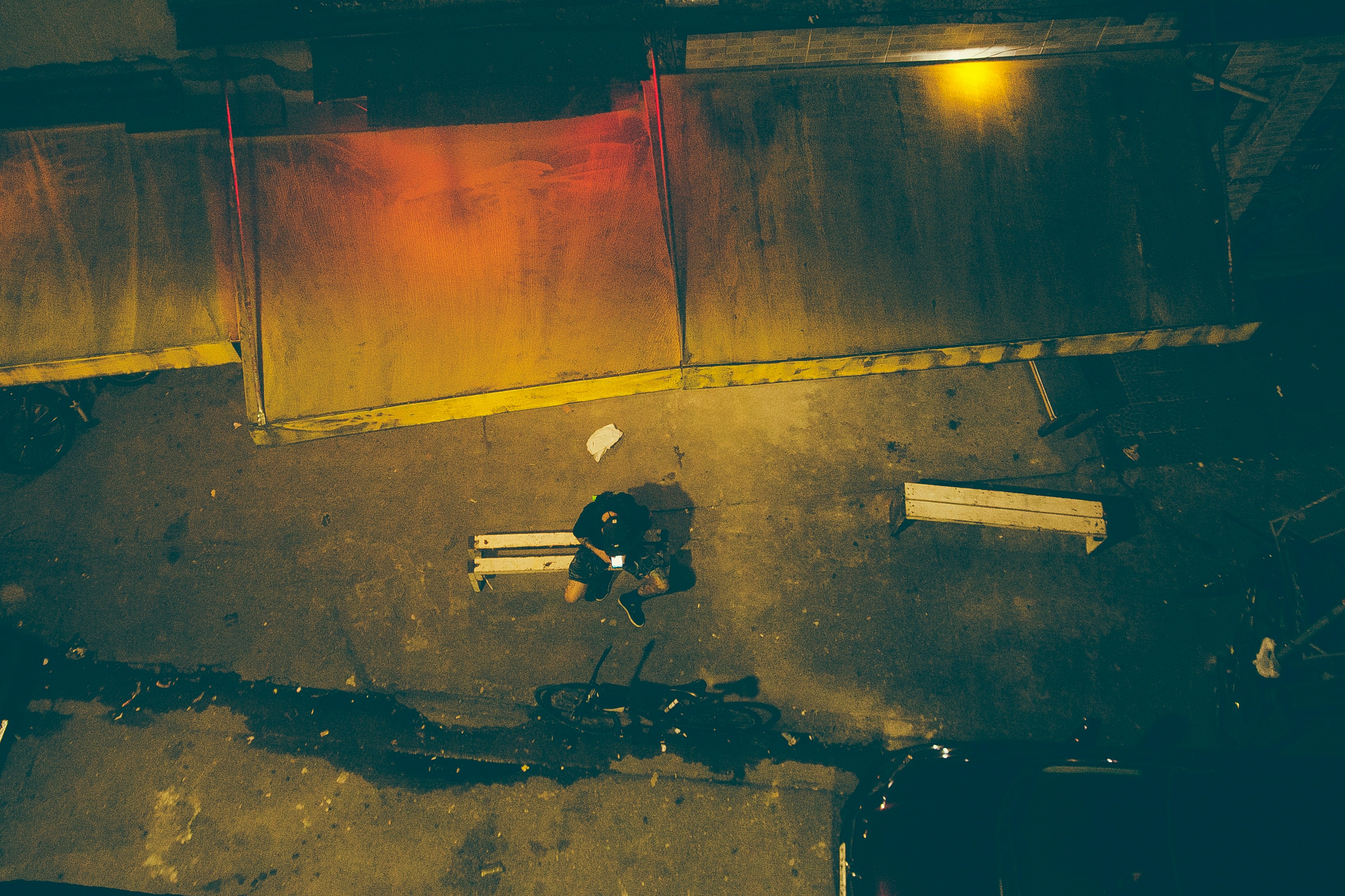 man in black jacket and pants standing beside brown wall