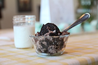 A spoon scooping a generous portion of crushed Oreos to fold into the cheesecake filling.