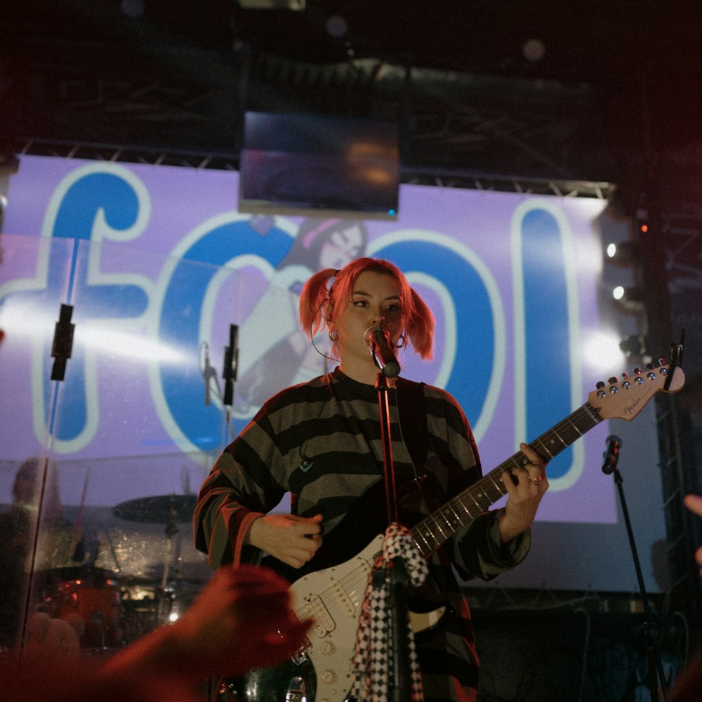 man in black and white plaid dress shirt playing electric guitar