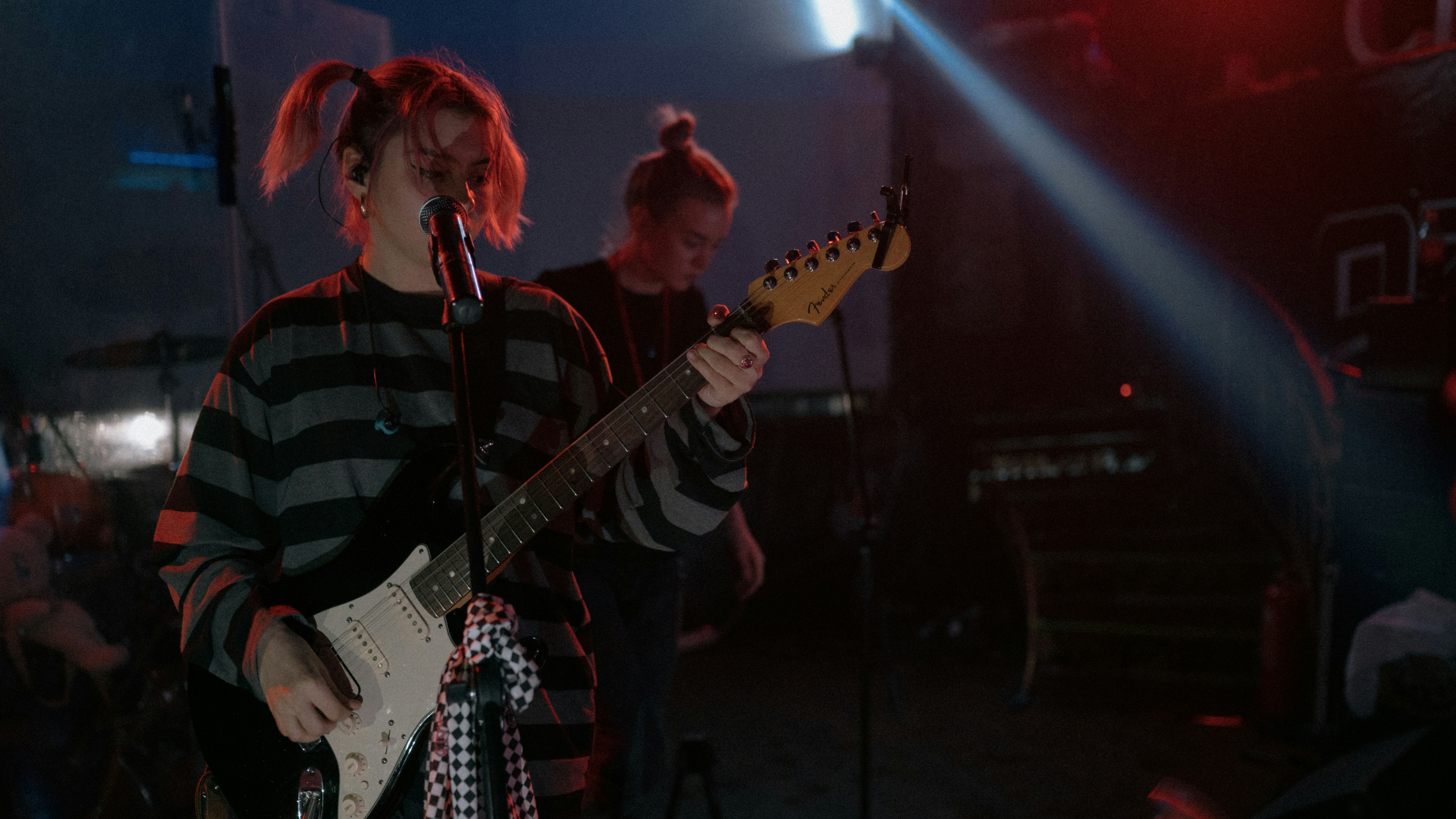 man in black and white striped shirt playing electric guitar