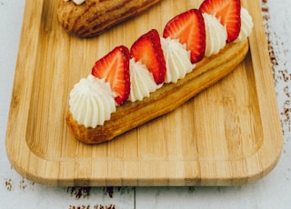 sliced strawberry and strawberry on brown wooden chopping board