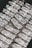 Stacks of shiny silver bars are neatly arranged, each bar featuring engravings and distinctive markings.