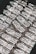 Stacks of shiny silver bars are neatly arranged, each bar featuring engravings and distinctive markings.