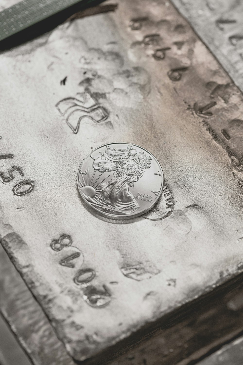 silver round coin on brown wooden table