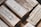 A collection of silver bullion bars, intricately engraved with various inscriptions, stamps, and symbols, stacked closely together. The bars have a reflective surface and display a rich metallic texture.